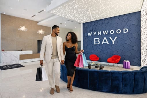A man and woman are standing in front of a Wynwood Bay sign.