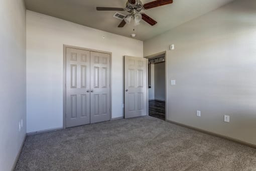 a bedroom with a ceiling fan and closet