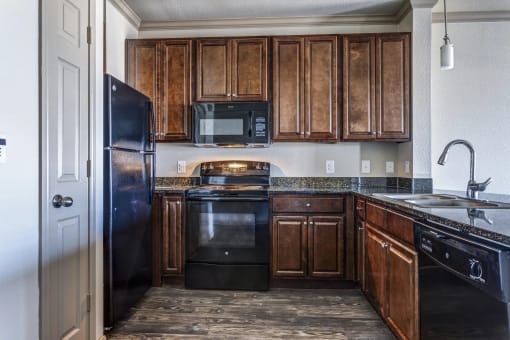 a kitchen with wooden cabinets and black appliances