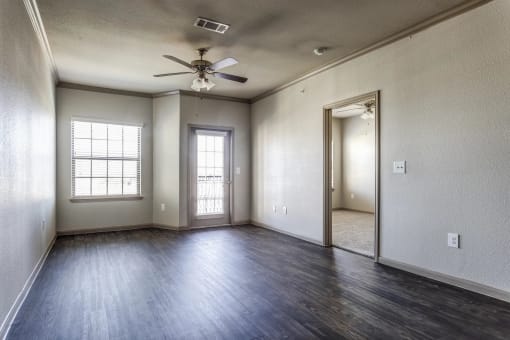 an empty living room with a ceiling fan