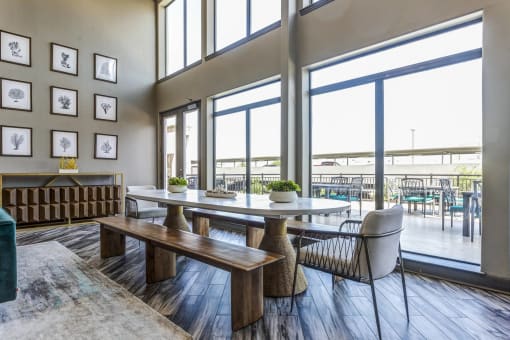 a dining area with a table and chairs and large windows