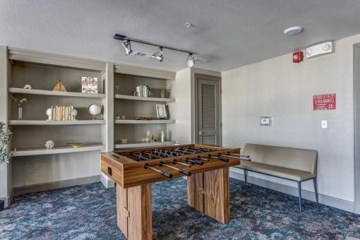 a room with a foosball table and a bench