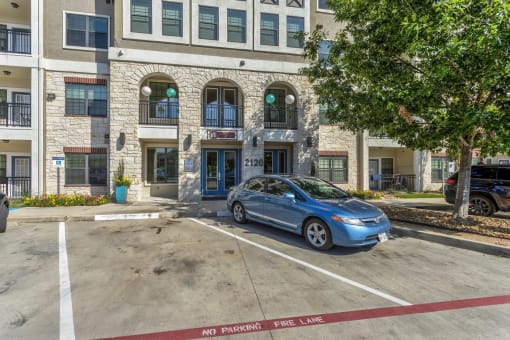a blue car parked in front of a building
