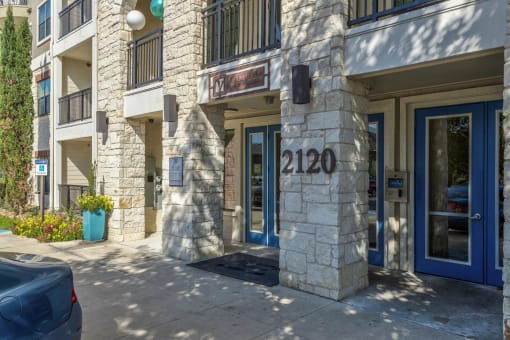 a building with a blue door and a stone facade with the number 2100 on it