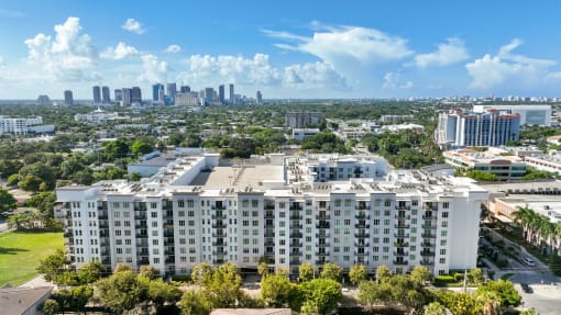 an aerial view of an apartment building with the city skyline in the background