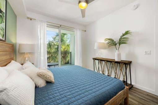 a bedroom with a blue bed and a balcony