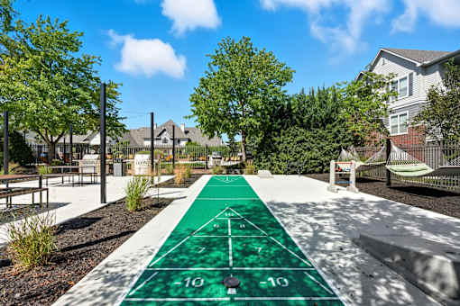 A green and white running track in a park.