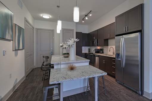 A kitchen with a marble island and stainless steel appliances.