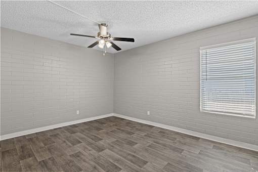 A room with a ceiling fan and a window with blinds.