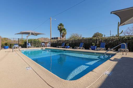 A swimming pool with blue water and a white umbrella.