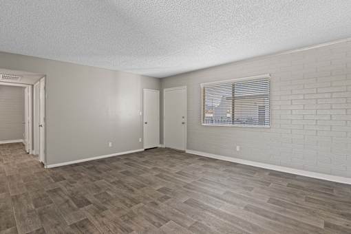 A room with a window and a wooden floor.