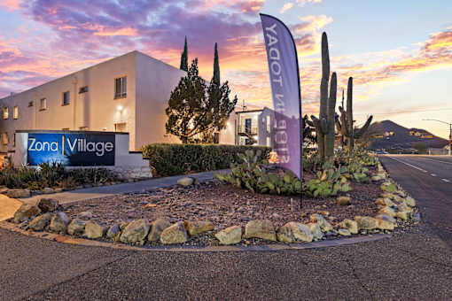A building with a sign that says Zona Village.
