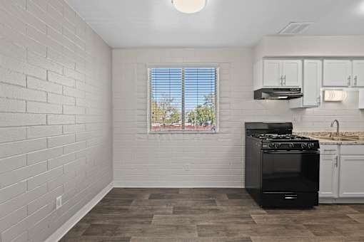 A kitchen with a black stove and white cabinets.
