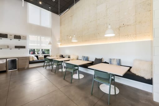 a dining room with tables and chairs and a kitchen