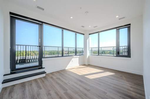 a living room with large windows and a balcony