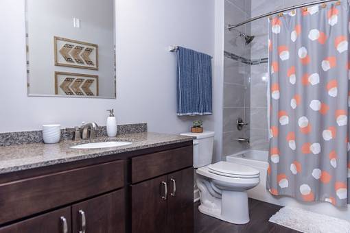A bathroom with a toilet, sink, and shower curtain.