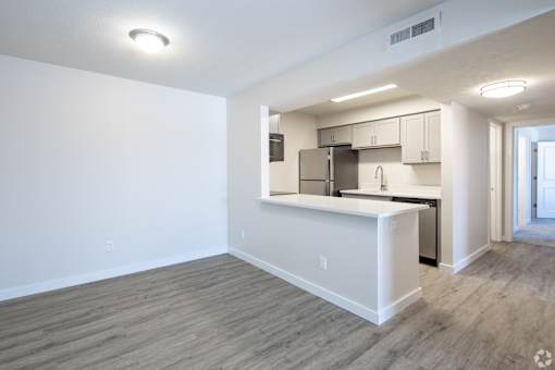 A kitchen area with a white counter and a refrigerator.