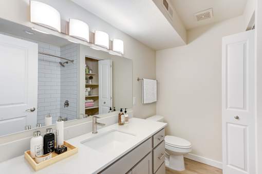 A bathroom with a white sink and a white toilet.