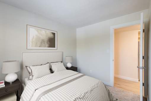A bedroom with a bed, nightstand, and lamp.