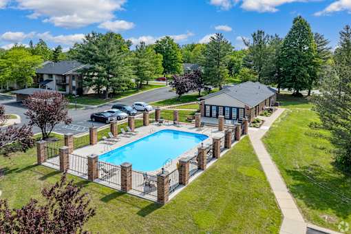 A pool surrounded by a fence and a grassy area.