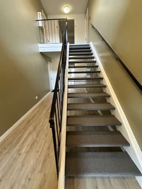 a set of stairs with a railing and wood floors