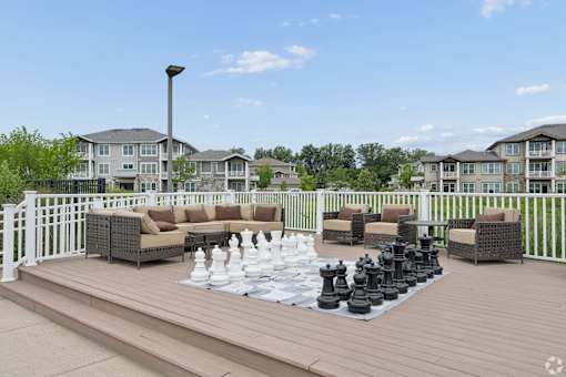 A giant chess set is set up on a wooden deck.