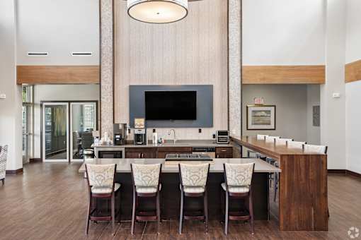A modern kitchen with a large island and chairs.