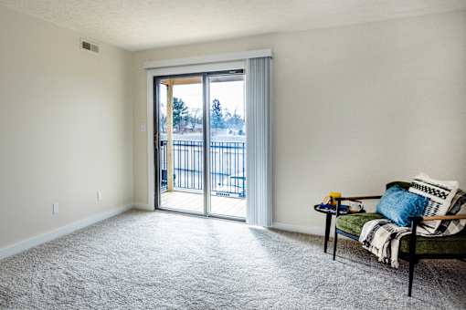 A living room with a couch and a table in front of a sliding glass door.