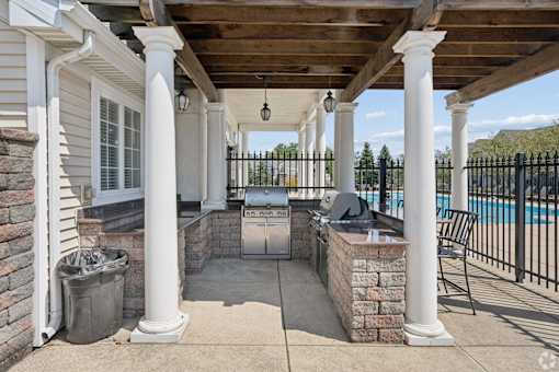 A patio with a pool in the background.