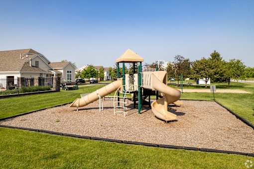 A playground with a yellow and green slide.