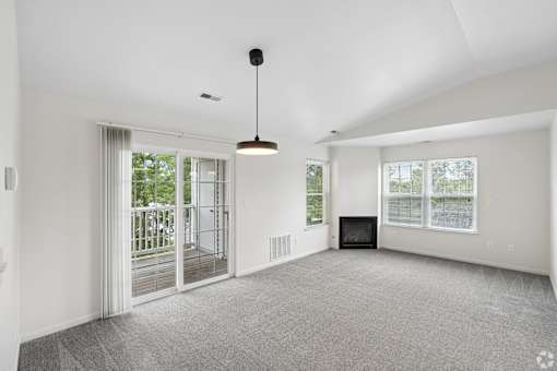 A spacious living room with a fireplace and sliding glass doors.
