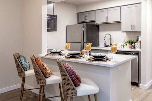 A kitchen with a white countertop and a black refrigerator.