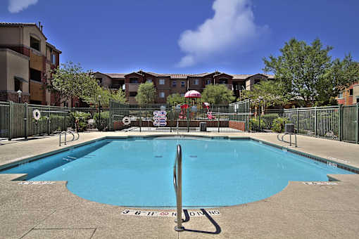 A large blue swimming pool surrounded by a fence.