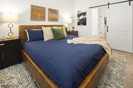 a bedroom with a large bed with blue blankets and pillows at Aura Vegas Apartments, Nevada, 89103