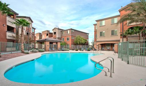 A swimming pool surrounded by a fence and buildings.