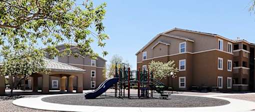 A playground with a slide in front of a building.