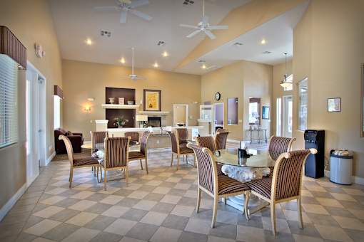 A dining room with a checkered floor and a fireplace.