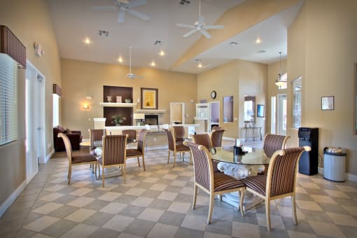 a dining room with tables and chairs and a living room with a fireplace