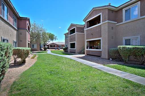A sunny day at a residential area with apartment buildings and green lawns.