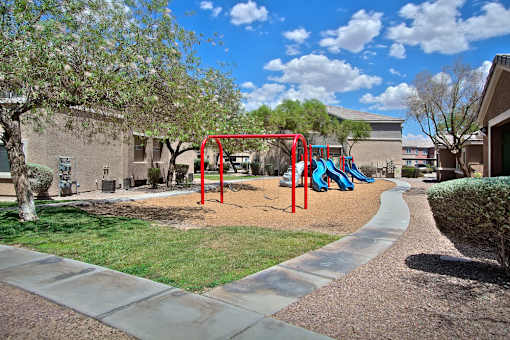 A playground with a red swing set and a blue slide.