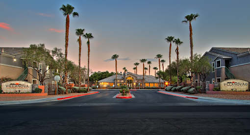 A street view of a residential area with palm trees and houses named Villanova.