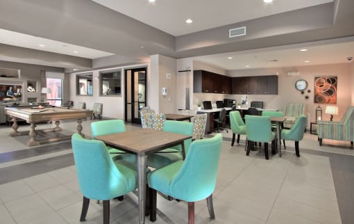 a clubhouse with tables and chairs and a pool table