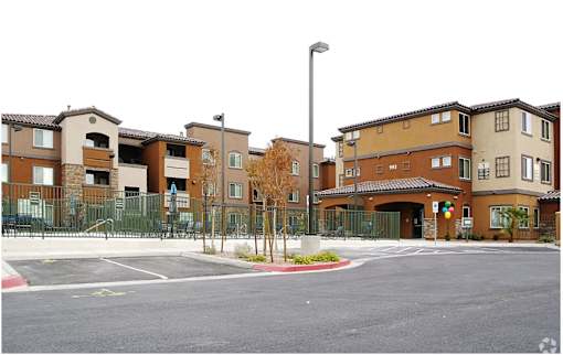 A street view of a gated community with apartment buildings.