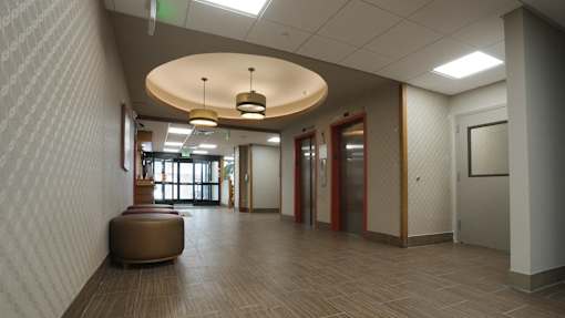 A hallway with a round light fixture and a bench at Denver Metro Village Apartments, Denver, 80204