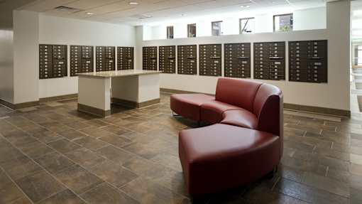 A red chair sits in front of a wall of black plaques at Denver Metro Village Apartments, Denver, CO