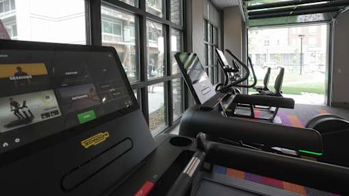 A treadmill with a screen showing a workout session at Denver Metro Village Apartments, Denver, CO, 80204