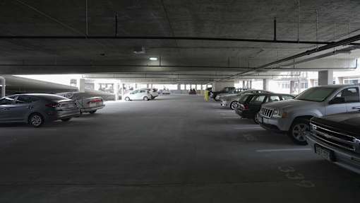 A parking garage with several cars parked in it at Denver Metro Village Apartments, Denver