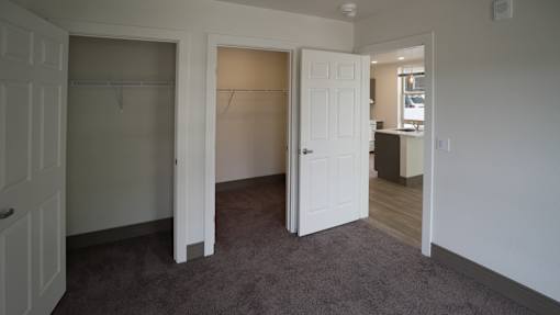A room with a carpeted floor and two open doors at Denver Metro Village Apartments, Denver, CO