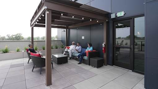 A group of people are sitting on a patio at Denver Metro Village Apartments, Colorado, 80204