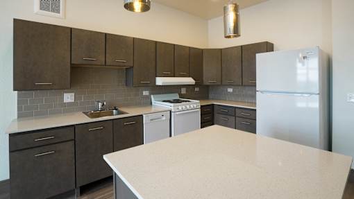 A kitchen with a white counter top and brown cabinets at Denver Metro Village Apartments, Denver, 80204